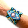 Pulsera tejida con chaquira y ojo de madera pintado a mano
