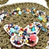 Bolsa redonda con tejido macramé y mariposa bordada